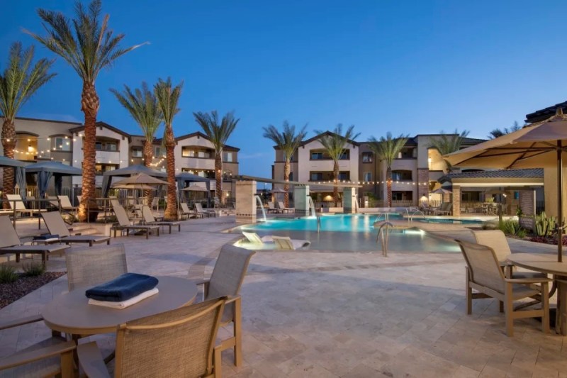 A pool and palm trees in front of a building