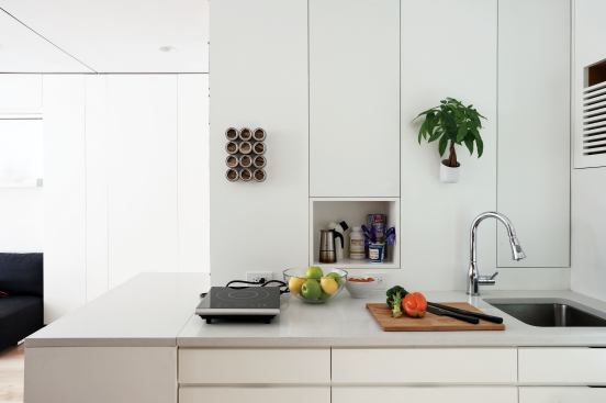 The tiny but functional kitchen employs induction burners and plenty of storage.