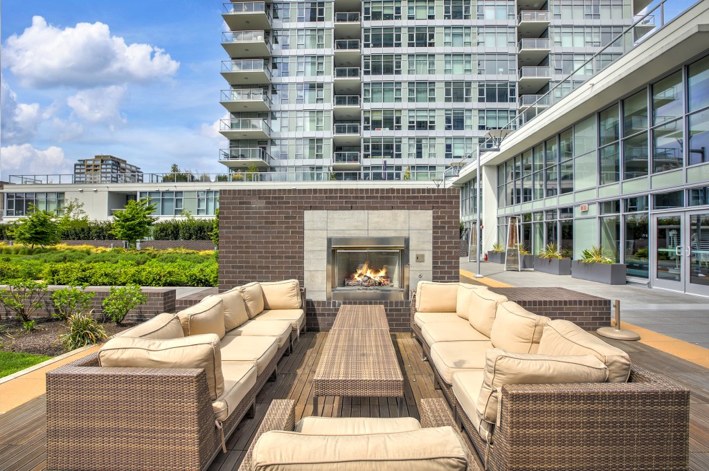 Contemporary open-air park with spacious lounge area equipped with wicker furniture and brick fireplace. Northwest, USA